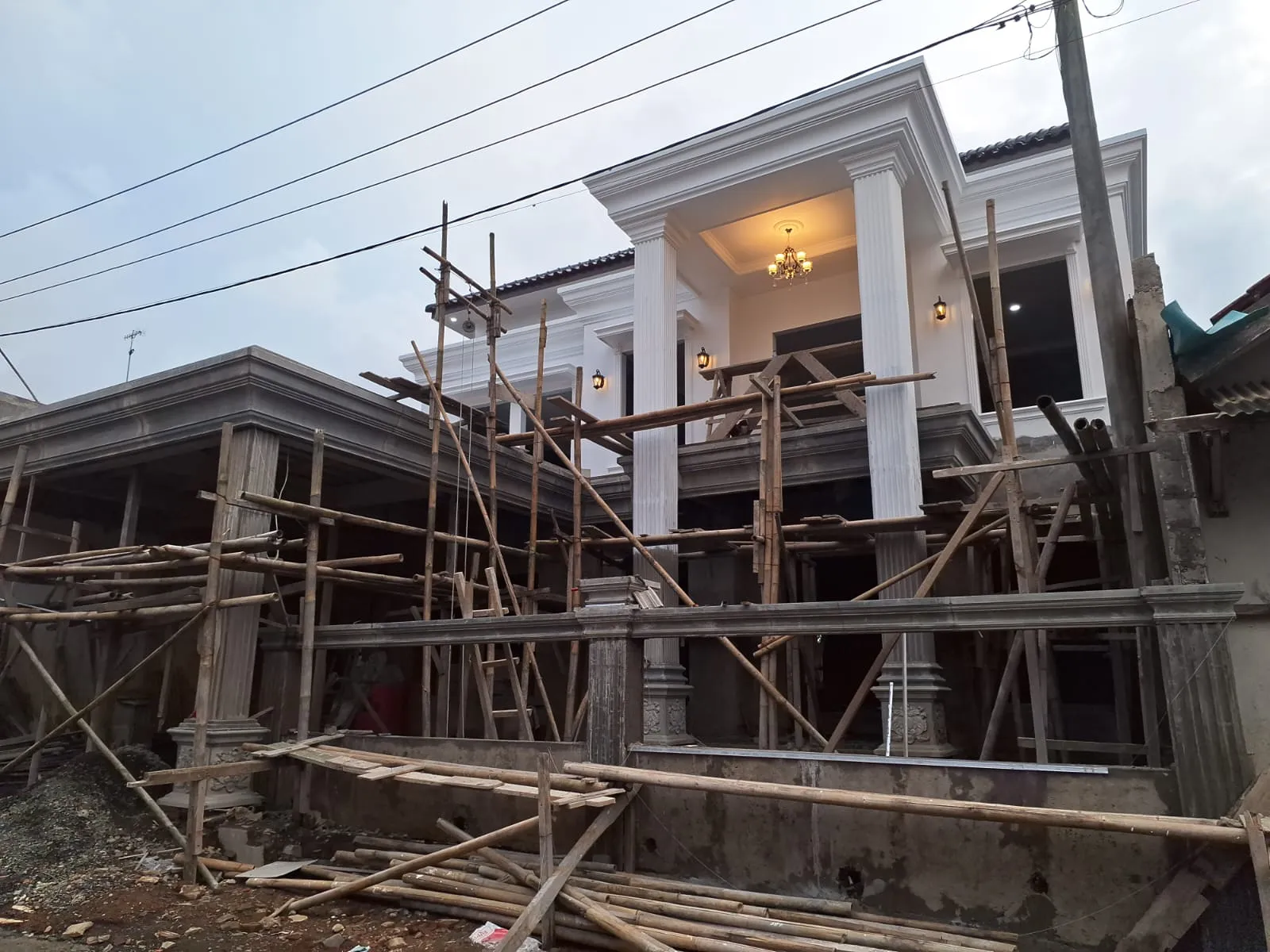 Teras rumah dengan kolom klasik dan taman setelah renovasi