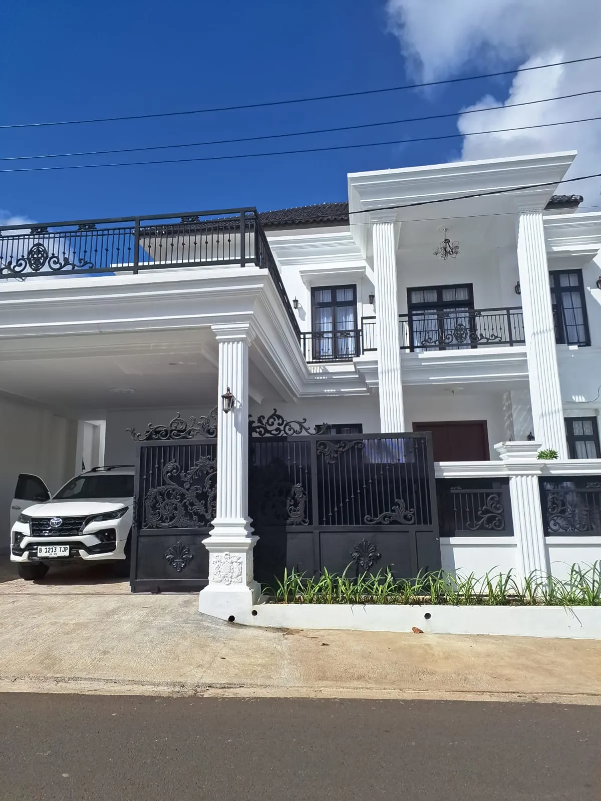 Rumah dua lantai bercat putih dengan gerbang tempa setelah selesai dikerjakan